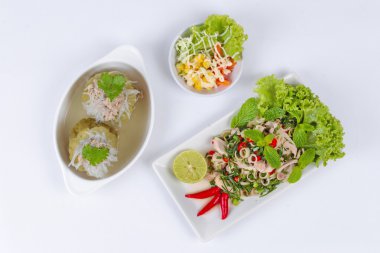 Domuz eti ve tavuk ile baharatlı ve ekşi karışık bitki salatası garnitür ve mini sebze salatası ve kemik çorbası içinde kabak şal erişte ve kıyılmış domuz eti ile servis edilir. Üstte görüntü