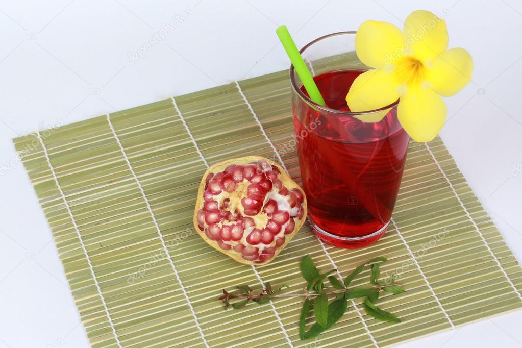 Pomegranate juice and peeled ripe  pomegranate on bamboo. 