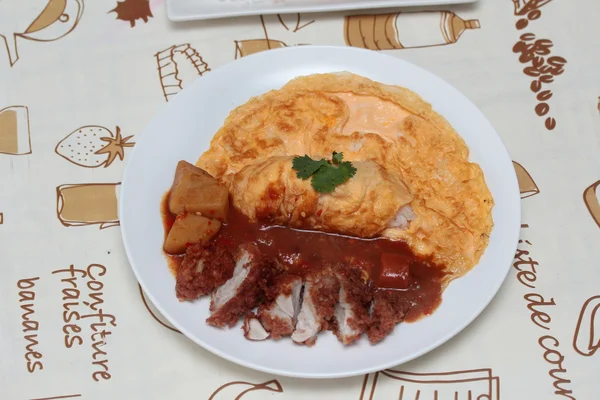 Omelet rijst met gefrituurde kip in Japanse gele curry op bruin. Selectieve focus. — Stockfoto