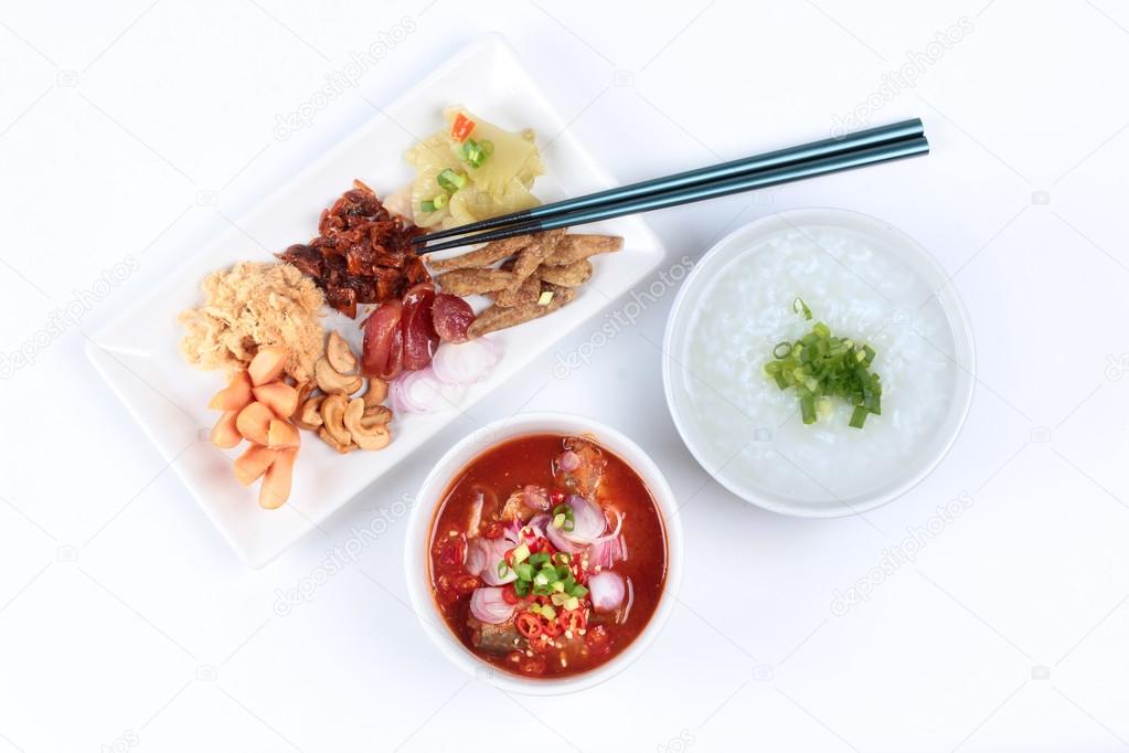 Rice gruel and  side dish  on white background. (Dried shredded pork,Chinese sausage,crispy fish,sausage, fried baby clams,sliced red onion,pickle Chinese cabbage ,Spicy sardine salad and shallots )