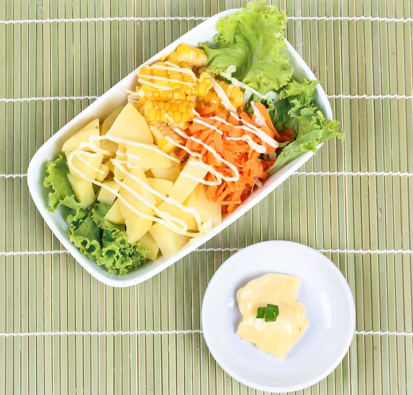 Plat de salade comme pomme de terre en streaming, maïs sucré, laitue et carotte hachée avec crème de salade remplie sur le bambou . — Photo