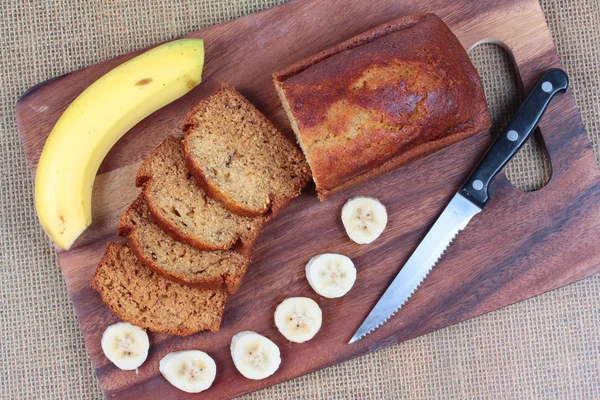 Kasap üzerinde dilimlenmiş muz ve bıçak ile ev yapımı muz kek servis.