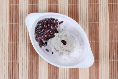 Siyah fasulye ve tatlı hindistan cevizi kreması yapışkan pirinç kahverengi hindistan cevizi sütü tepesinde. Üstte görüntü.