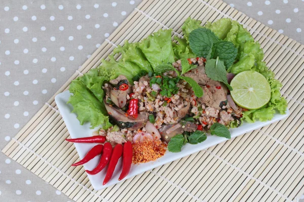 Spicy and sour mixed herb salad with pork and chicken on bamboo and gray. Side view. — Stock Photo, Image