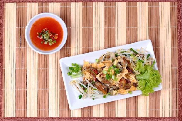 Huître frite aux germes de haricots et échalote comme "Hoi Tod" en thaï servi avec de la sauce chili. — Photo