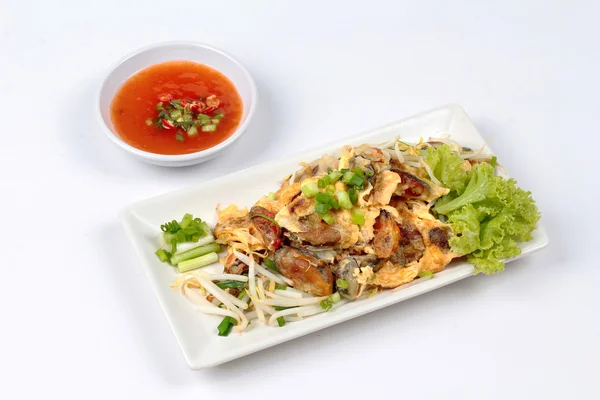 Gebratene Auster mit Sojasprossen und Schalotte als "hoi tod" in Thai serviert mit Chilisoße. Seitenansicht — Stockfoto