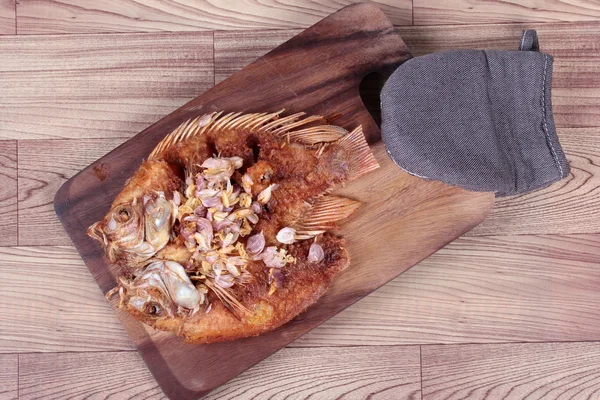 Frittierter Fisch, Niltiapia, mit knusprigem Knoblauch auf Fleischplatte serviert. Ansicht von oben. — Stockfoto