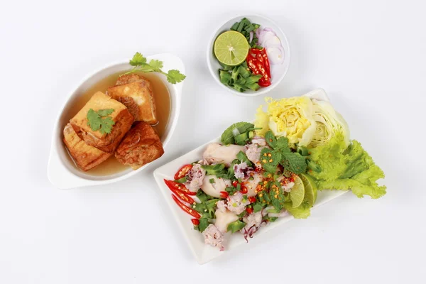 Gold bar soup as fried tofu wrap minced pork in soup served with spicy and sour mixed herb salad with squid wrap minced pork . Top view. — Stock Photo, Image