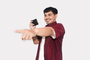 Mutlu Asyalı genç adam, siyah cüzdan tutuyor, beyaz arka planda kestane rengi gömlek giyiyor, Finansal Fırsat kavramı.