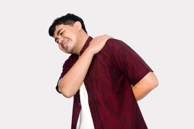 Şiddetli omuz ve sırt ağrısı çeken bir adam, sade beyaz bir arka planda huzursuzluk içinde, Sağlık Konsepti.