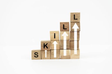 Wooden blocks stacked in a staircase formation, spelling out SKILL with upward-pointing arrows, symbolizing growth and development on a white background.