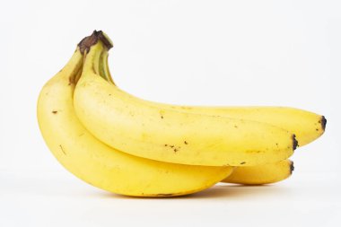 Küçük bir grup sarı muz, beyaz bir yüzeyde taze tropikal meyveler göstererek yatay olarak izole edilir..