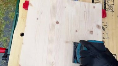 Elektrikli odun öğütücüsüyle öğütme, sağlam ahşap mobilyaların restorasyonu. Ahşap. Atölyede orbital zımpara makinesi ile ahşabı zımparala, video. Yüksek kalite 4k görüntü