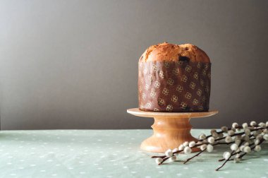 Easter pie Panettone on a wooden stand with pussy willow. Easter concept.