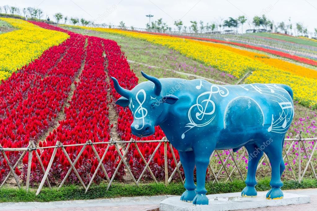 Colorful flower field with blue cow statue 