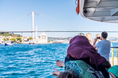 İstanbul 'da boğazdaki Boğaz Köprüsü ve deniz manzarasının tadını çıkaran bir yolcu gemisinde turistler, tatil kavramı
