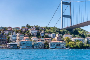 İstanbul 'da boğazın kıyısındaki güzel binalarla İstanbul Boğazı' ndan geçen Boğaz Köprüsü 'nün güzel manzarası İstanbul Boğazı' nda seyreden bir yolcu gemisinin manzarası.