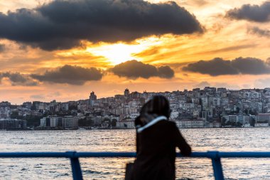 İstanbul, Türkiye 'nin Uskudar kentindeki Corniche parkında günbatımını izleyen Müslüman bir kadın turist, İstanbul' un Anadolu kıyısındaki Boğaz 'da.