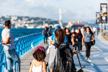 İstanbul, İstanbul, Türkiye 'deki Uskudar' daki Corniche parkında, İstanbul Boğazı 'nın Anadolu kıyılarında yürüyen insanlar.