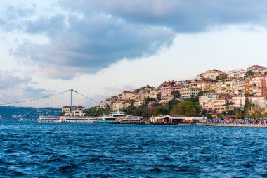 İstanbul, İstanbul, Türkiye 'deki Uskudar' da, İstanbul Boğazı 'nın Anadolu kıyısında gün batımının altında güzel binalar ve köprü.