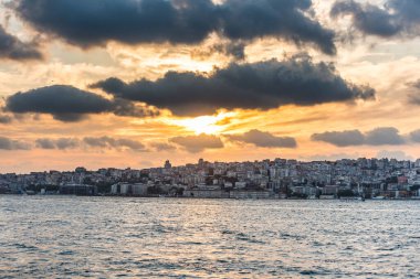 Altın gün batımının altında bir sürü bina bulunan Boğaz 'ın güzel manzarası, İstanbul, Türkiye, Uskudar' dan İstanbul 'un İstanbul' un Anadolu kıyısındaki Boğaz manzarası.