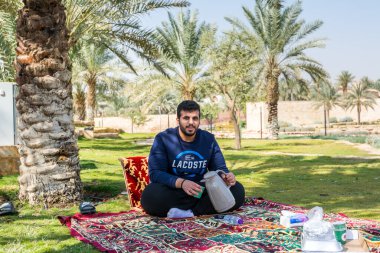 Diraiyah harabelerinde çay yapan ve halı üzerinde oturan Arap bir erkek, aynı zamanda Riyad, Suudi Arabistan 'da bir kasaba olan Dereyeh ve Dariyya gibi.