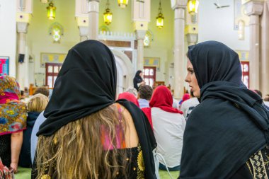 Müslüman olmayan konuklar, Dubai 'de halka açık ve gayrimüslim misafirleri kabul eden tek cami olan Jumeirah Camii' nin içindeki Müslüman bir bayan öğretmenden ders dinliyorlar. 
