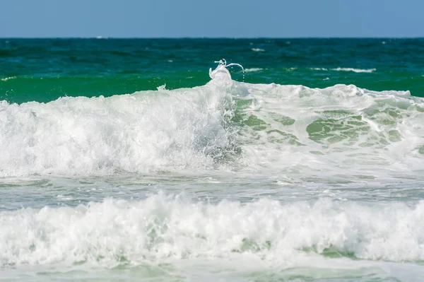 Waves,  water splash flushing beach at Jumeirah beach at Persian gulf in Dubai, United Arab Emirates.