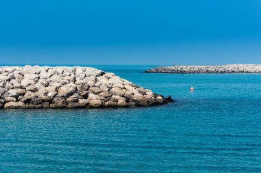 Abu Dabi, Birleşik Arap Emirlikleri 'ndeki Corniche parkındaki Basra Körfezi' ndeki mavi deniz ve taş baraj..