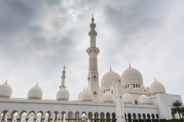 Beyaz bulutlu gökyüzüne karşı Beyaz Cami 'nin minare ve kubbeleri aynı zamanda Şeyh Zayed Büyük Camii olarak da adlandırılır, Pers, Babür ve Fas camii mimarisinden esinlenilmiştir.
