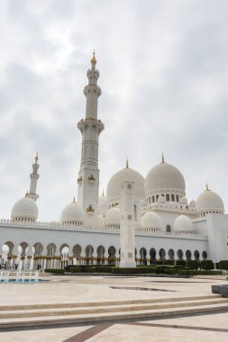 Beyaz bulutlu gökyüzüne karşı Beyaz Cami 'nin minare ve kubbeleri aynı zamanda Şeyh Zayed Büyük Camii olarak da adlandırılır, Pers, Babür ve Fas camii mimarisinden esinlenilmiştir.