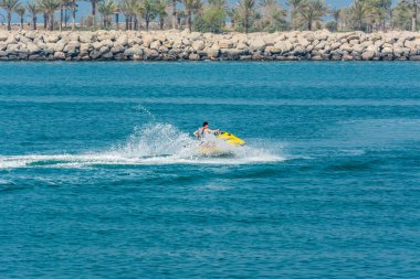 Abu Dabi, Birleşik Arap Emirlikleri 'nde İran körfezinde jet ski süren bir turist.