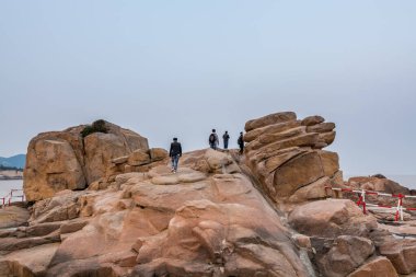 Çin 'de Bodhisattva Avalokitesvara' nın (Guanyin) ünlü bir bölgesi olan Putuoshan, Zhoushan Adaları 'nın kayalıklarında duran turistler)
