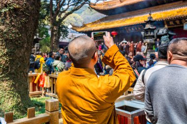 Putuoshan, Zhejiang 'daki Puji Tapınağı' nda cep telefonuyla fotoğraf çeken bir keşiş, Bodhisattva Avalokitesvara 'nın (Guanyin)