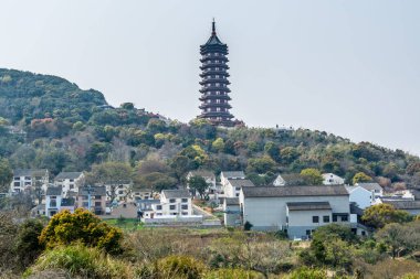 Putuoshan dağlarındaki pagoda kulesinin arka planına sahip Çin geleneksel otel ve köyü, Çin 'de Bodhisattva Avalokitesvara' nın ünlü bir yeri olan Zhoushan Adaları (Guanyin)