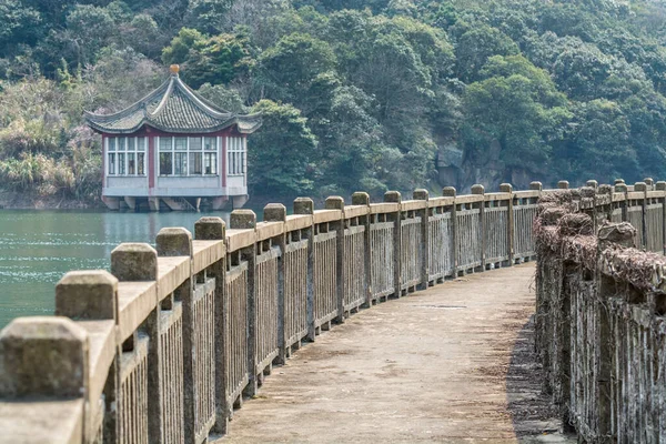 Chinese traditional pavilion and bridge next to lake in the Putuoshan mountains, Zhoushan Islands,  a renowned site in Chinese bodhimanda of the bodhisattva Avalokitesvara (Guanyin)