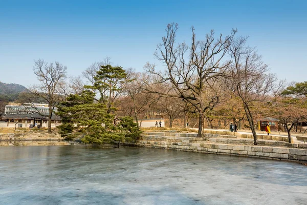 Frozen lake and withered tree and Korean wooden traditional house in Gyeongbokgung,  also known as Gyeongbokgung Palace or Gyeongbok Palace