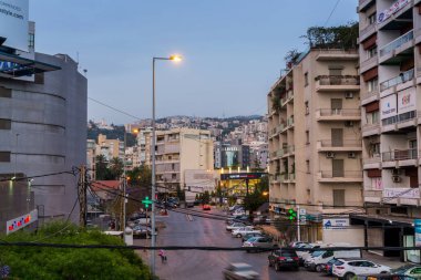 Lübnan Beyrut 'ta dağın arka planına sahip binaların gece görüşü.