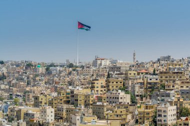 Amman şehrinin çok sayıda binası ve Ürdün ulusal bayrağı, Ürdün 'ün başkenti ve en kalabalık şehri, Arapça' da Jabal el-Qal 'a olarak bilinen Amman Kalesi' nin görüşü.