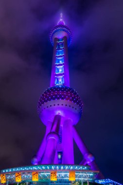 Night view of the The Oriental Pearl Tower at a cloudy day after raining with colorful  light in Pudong, Shanghai, China. clipart
