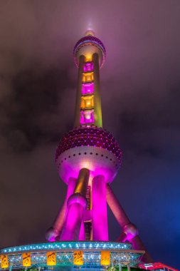 Pudong, Şangay, Çin 'de renkli ışıkla yağmurun ardından bulutlu bir günde Doğu İnci Kulesi' nin gece manzarası.