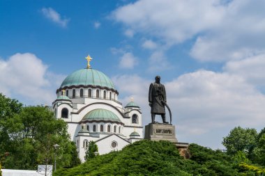Karadjordje statue against blue sky  and church of Saint Sava, a Serbian Orthodox church located in Belgrade, Serbia clipart