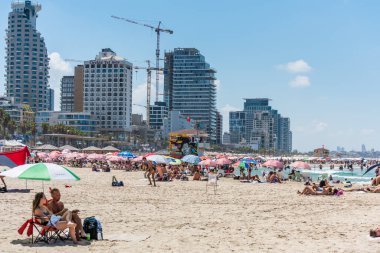 Birçok turist tatillerini ve şemsiyelerini İsrail 'in Tel Aviv plajında geçirirler..