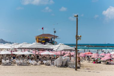 Birçok turist tatillerini ve şemsiyelerini İsrail 'in Tel Aviv plajında geçirirler..