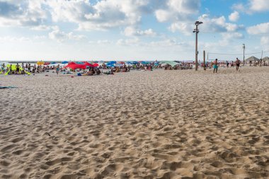 Birçok turist tatillerini ve şemsiyelerini İsrail 'in Tel Aviv plajında geçirirler..