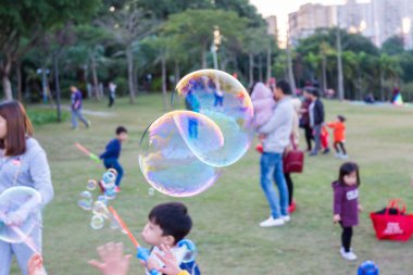  Shenzhen, Çin 'de park geçmişi olan bir parkta sabun köpüğü uçurmak.