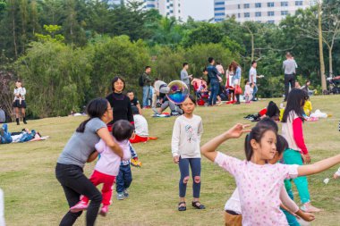 Sonbaharda insanlarla, ağaçlarla ve çayırlarla birlikte parkta uçan bir sabun köpüğü Longtan parkının yakınında, Shenzhen, Çin