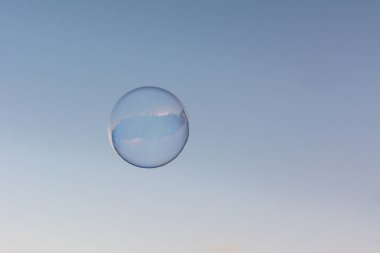 Mavi ve temiz gökyüzünde uçan bir sabun köpüğü