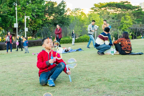 Longtan Park, Shenzhen, Çin 'de sabun köpüğü yapan Çinli bir çocuk.