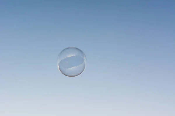A soap bubble flying in the blue and clean sky